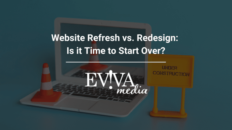 A laptop displaying "Website Refresh vs. Redesign: Is it Time to Start Over?" with a traffic cone and "Under Construction" sign on the keyboard and a white Eviva Media logo.