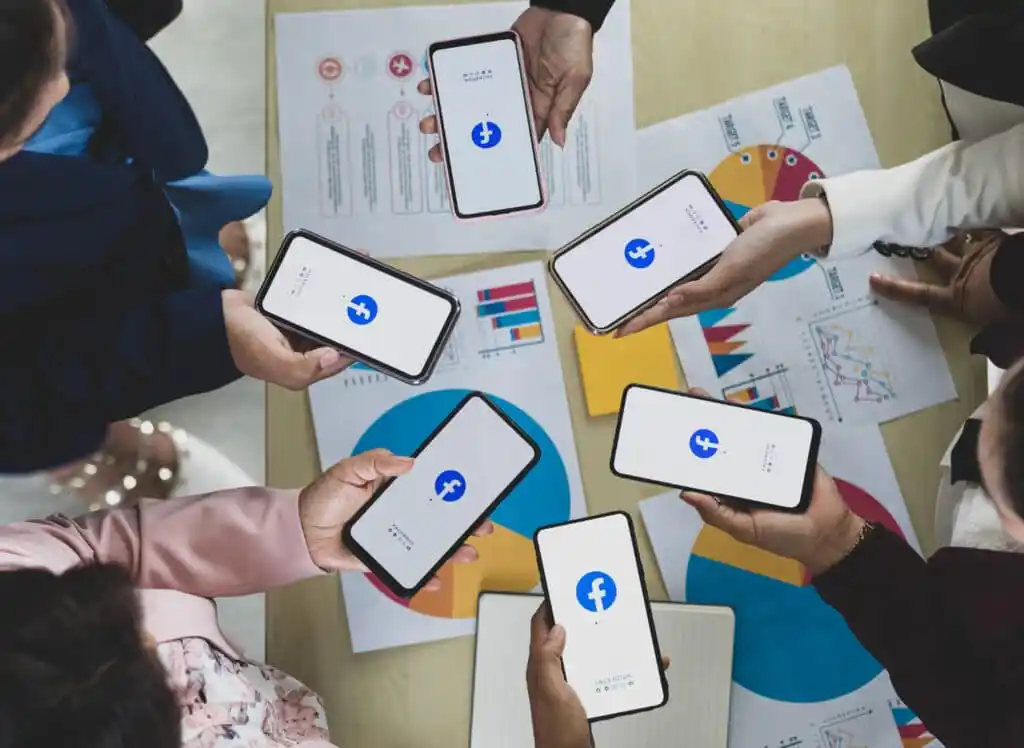 People holding smartphones with social app logos
